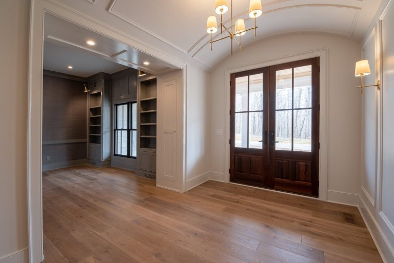 Empty foyer with wood flooring, wood doors and case openings